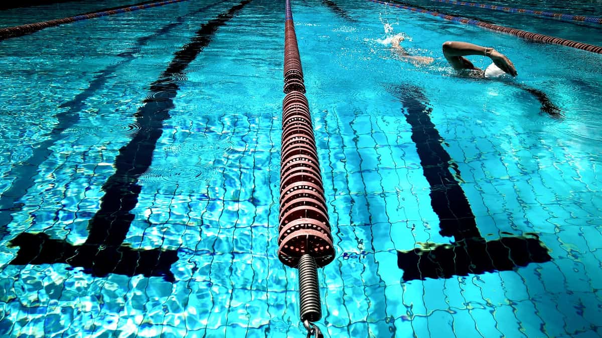 A person swimming in a clear outdoor lap pool