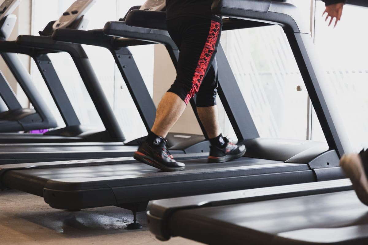 A person walking on a treadmill in a modern gym