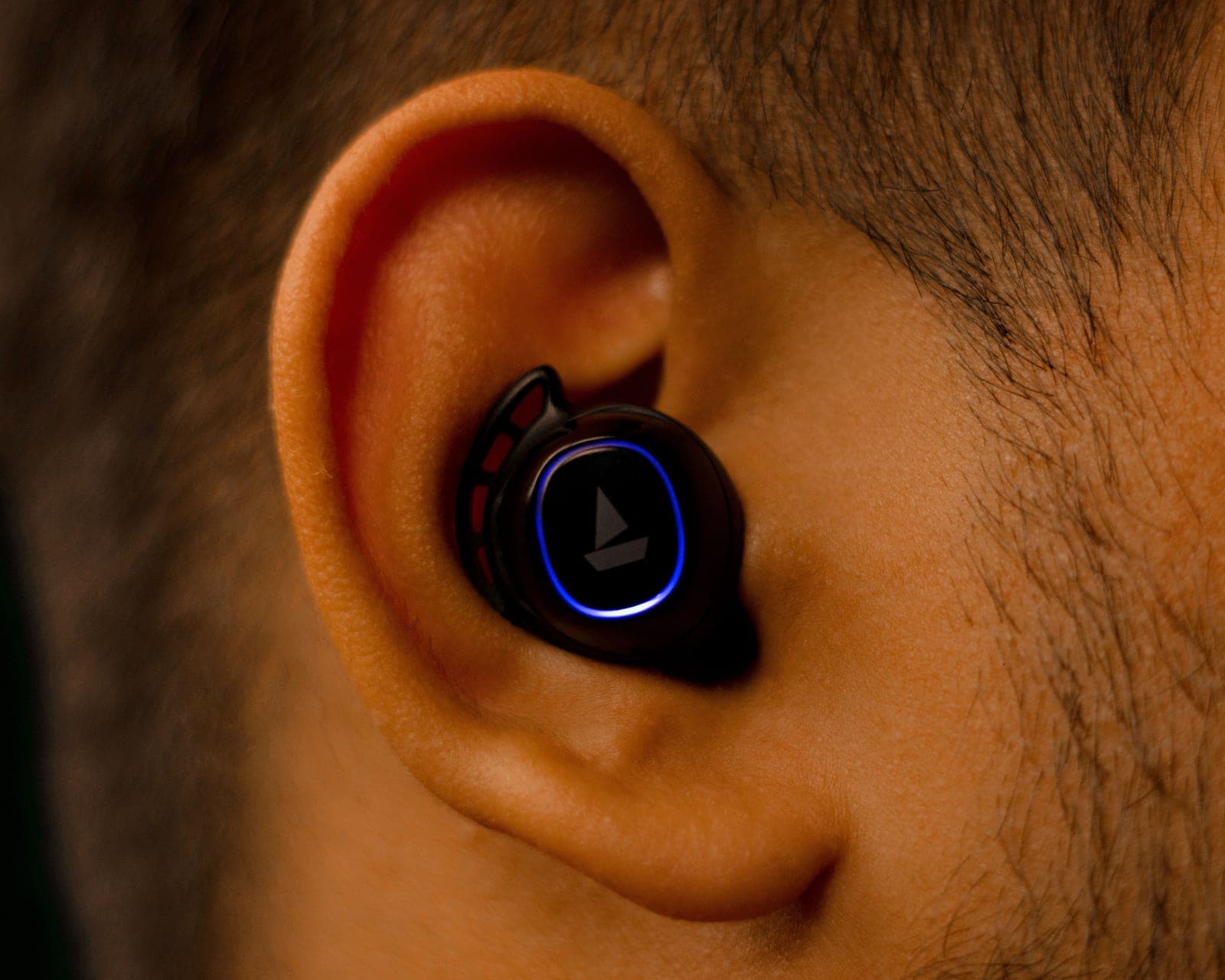 A close-up of a wireless earbud seated in a person's ear